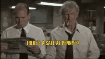 two men are standing next to each other reading newspapers .