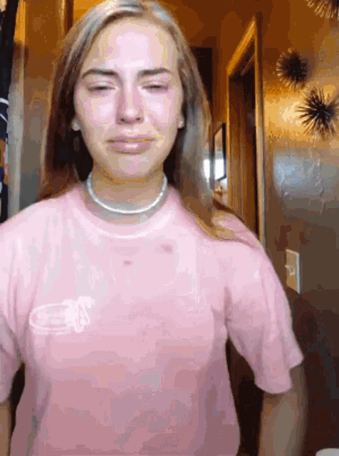 a woman wearing a pink t-shirt with the letter a on it