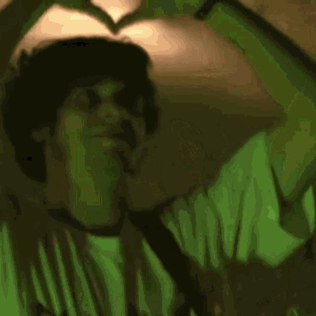 a man making a heart shape with his hands