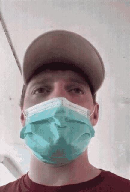a man wearing a mask and a hat is looking at the camera