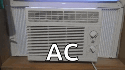 a white air conditioner is sitting on a wooden table .