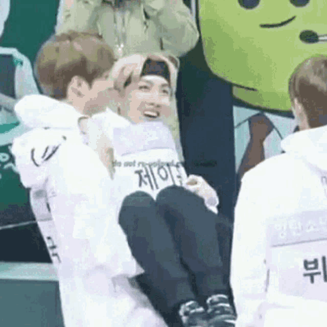 a man is carrying another man in his arms while another man watches .