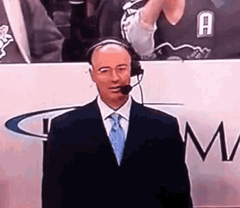 a man in a suit and tie is wearing a microphone and headphones .