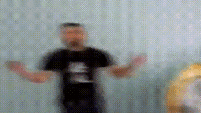 a blurry picture of a man in a black shirt with the letter e on it .