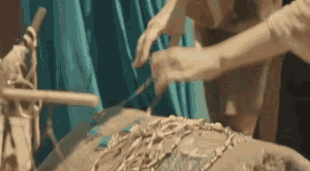 a close up of a person cutting a piece of wood with a knife on a table .
