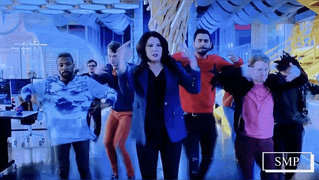a group of people are dancing in a room with a smp logo in the corner