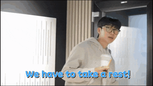 a man with glasses holds a cup of coffee and says we have to take a rest !