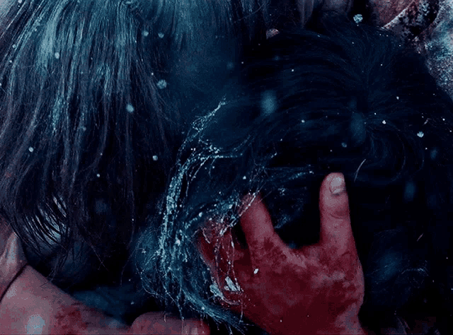 a close up of a person holding another person 's head with water coming out of it