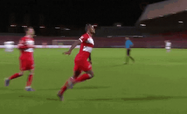 a man in a red and white jersey is running on a field