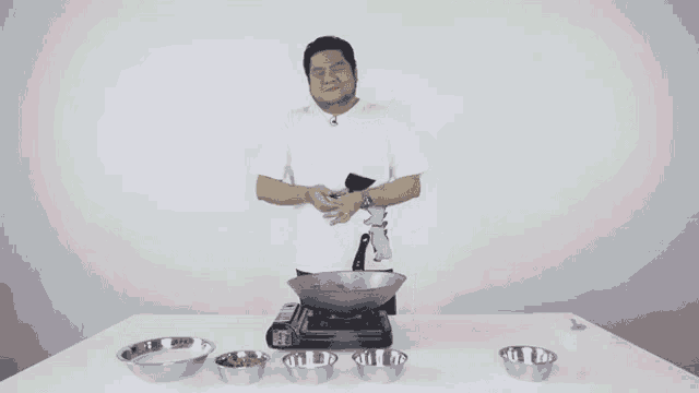 a man in a white shirt is cooking in a frying pan in front of a sign that says " ! "