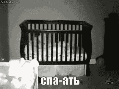 a black and white photo of a baby in a crib in a room .