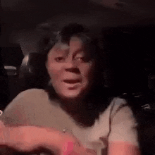 a woman is sitting in the back seat of a car and talking .