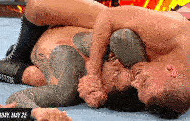 two men are wrestling in a ring with the date may 25 on the bottom