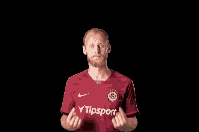 a man wearing a red shirt that says tipsport