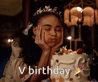 a girl with a tiara on her head is eating a birthday cake