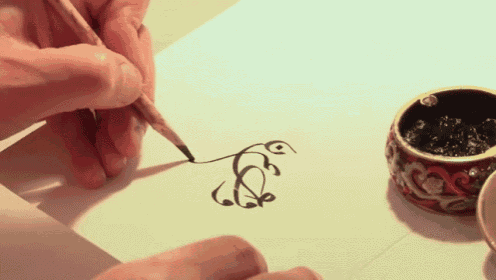 a person drawing a swirl on a piece of paper