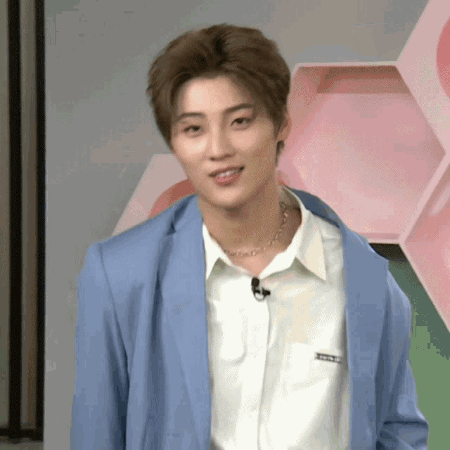 a man wearing a blue jacket and a white shirt has a microphone in his pocket