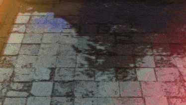 a shadow of a person is cast on a brick sidewalk