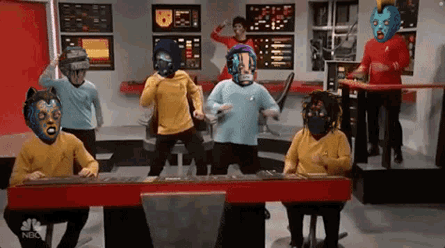 a group of people are dancing in a room with a nbc logo on the wall