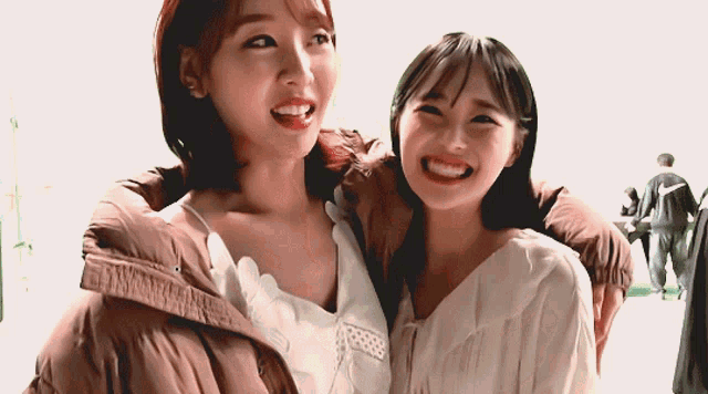 two women are posing for a picture together and smiling for the camera