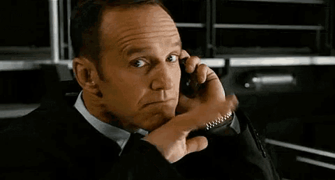 a man in a suit and tie is talking on a cellphone