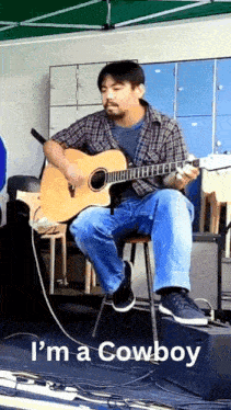 a man sitting on a stool playing an acoustic guitar with the words i 'm a cowboy written below him