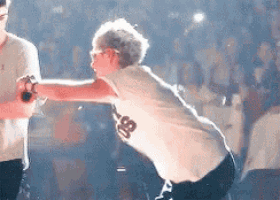 a man wearing a white shirt with the number 99 on it is dancing on a stage