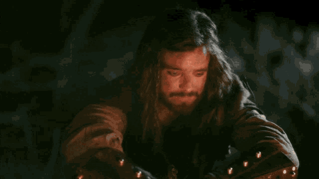 a man with a beard says but it 's not that simple in a dark room