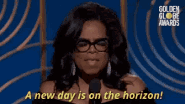 a woman is speaking into a microphone and says a new day is on the horizon .