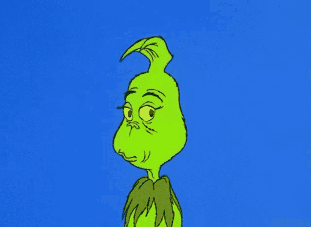 the grinch from the movie the grinch is looking at the camera with a very angry look on his face .