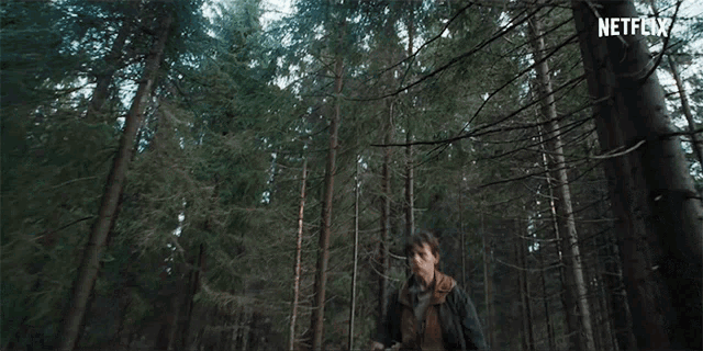 a man is running through a forest with a netflix logo in the corner