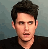 a close up of a man 's face with his mouth open and a surprised look on his face .