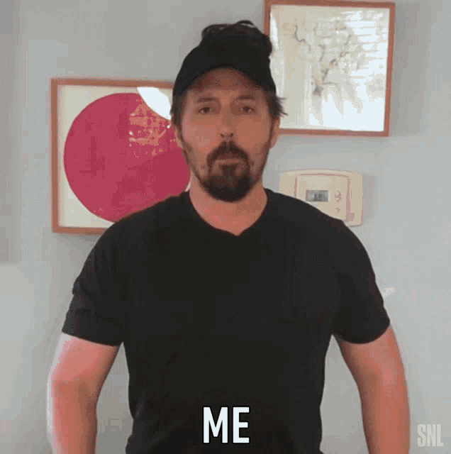 a man with a beard wearing a black shirt that says me on it