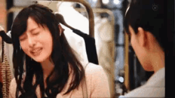 a woman is sitting in front of a mirror with her eyes closed .