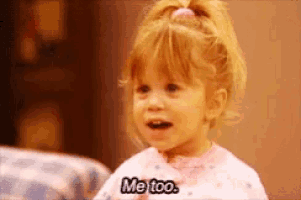 a little girl says " me too " in a pink shirt