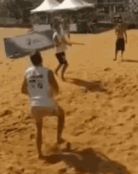 a group of people are playing a game of volleyball on a beach .