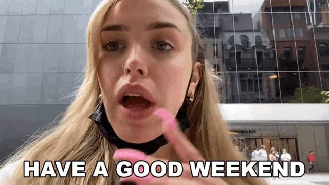 a woman wearing a mask says have a good weekend in front of a building