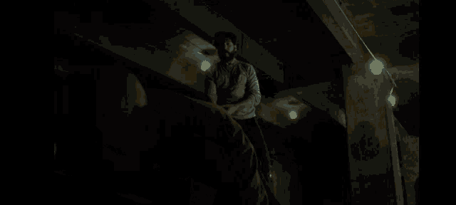 a person in a yellow shirt is laying on the ground in a dark room
