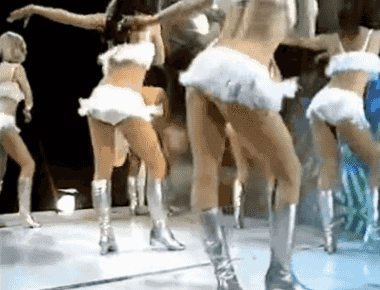 a group of women in white skirts and silver boots are dancing on a stage ..