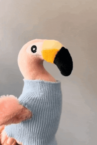 a stuffed flamingo with a blue sweater on