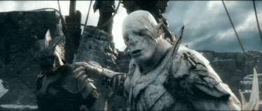 an orc is holding a bow and arrow in his hand .