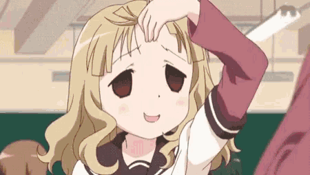 a girl with blonde hair is smiling and touching her forehead with her hand