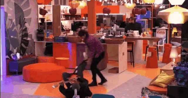 a man is cleaning a room with a vacuum cleaner and a sign that says ' vanilla ' on it