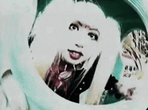 a woman with white hair is sticking her tongue out in a circle .