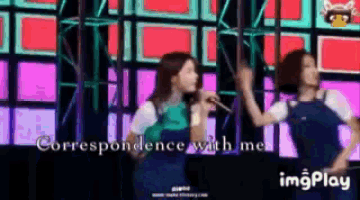 two women singing into microphones on a stage with the words correspondence with me in the corner