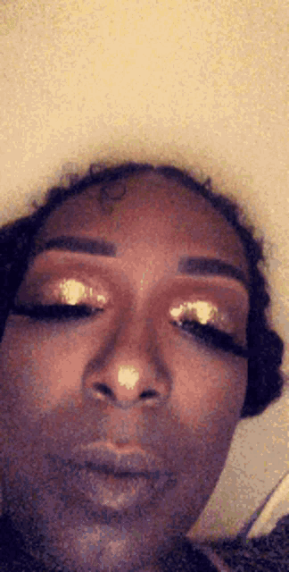 a close up of a woman 's face with her eyes closed and her makeup on .