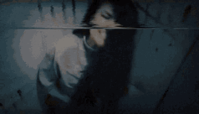 a woman is screaming in a dark room with her mouth open