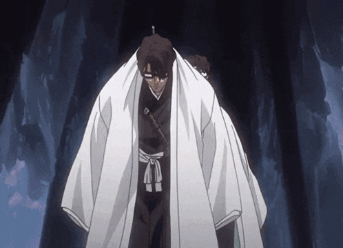 a man in a white kimono stands in a dark cave