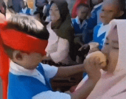 a boy wearing a red hat and a blue shirt is eating a hamburger .
