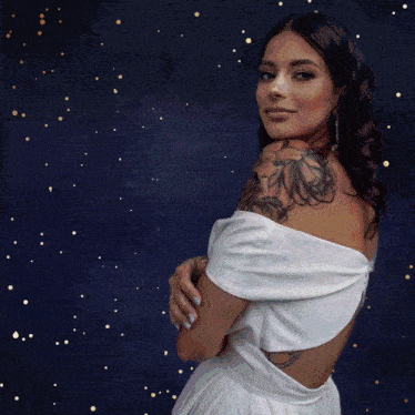 a woman with a tattoo on her shoulder wearing a white dress